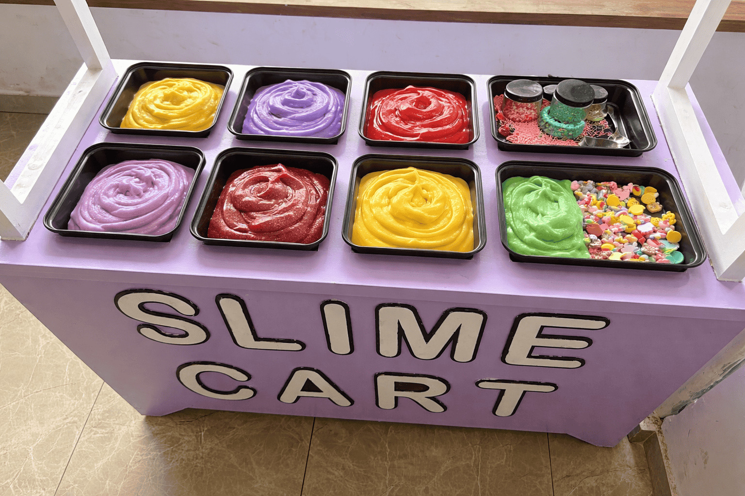 Child making colourful glitter slime at Splashit slime lab